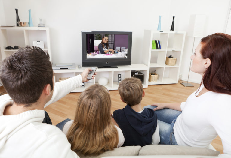 a family sits together to watch television