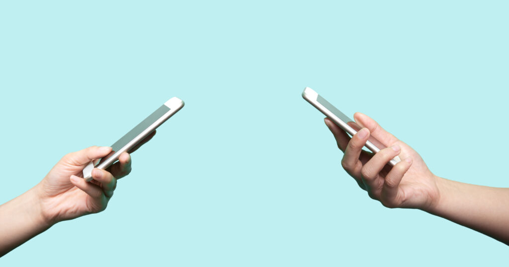 Two hands holding mobile phones