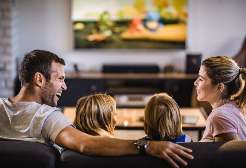 Happy family on couch streaming content on TV