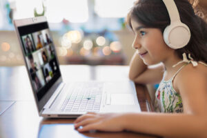 A little girl uses the internet to attend class virtually