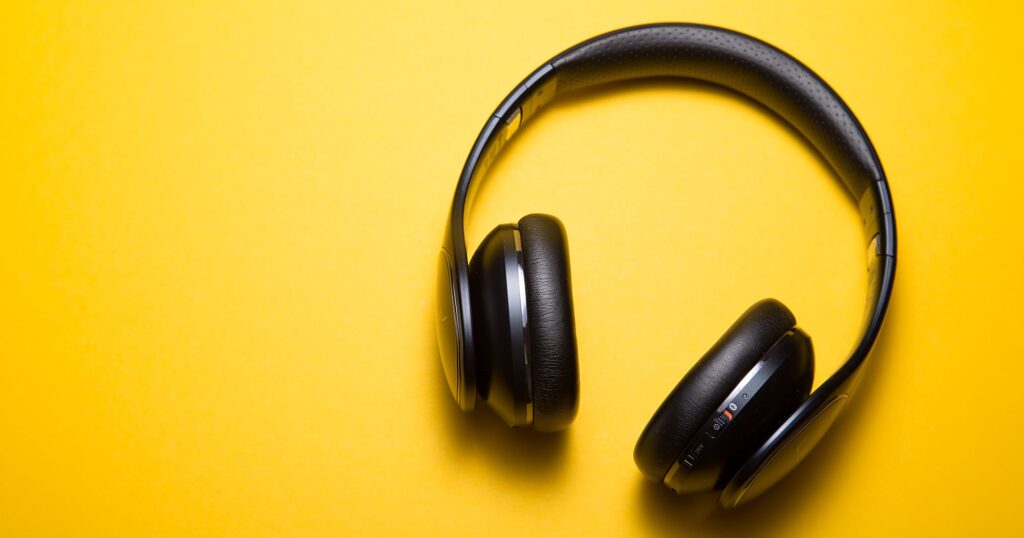 Photograph of headphones on yellow background - Best Music Streaming App