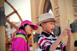 Photograph of two children using a smartphone - best phone plans for kids page