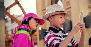 Photograph of two children using a smartphone - best phone plans for kids page