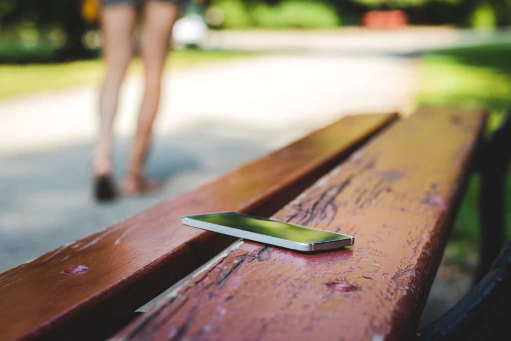 Woman forgetting her phone on a park bench