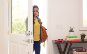 Woman entering through a door with an August Smart Lock Pro installed