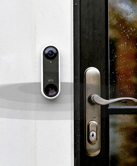 Arlo Video Doorbell mounted by a wooden door with glass windows