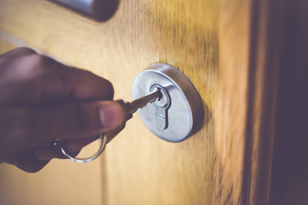 Hand holding a key in a door lock