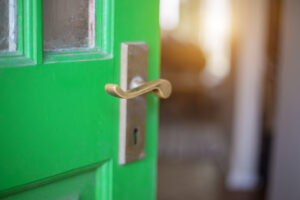 Ajar green door with brass handle