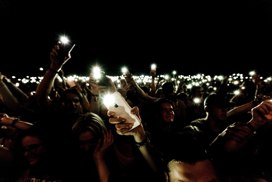 Smartphones in a crowd with flashlights on