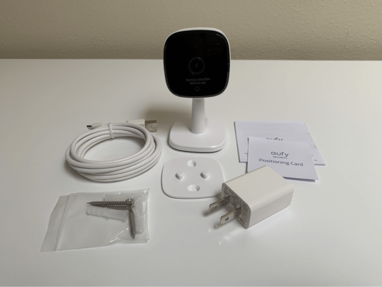 A Eufy camera and its equipment including a charging cord, wall plug in, mount, screws, and installation guide.