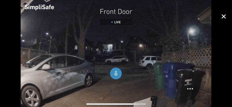 Screenshot of the SimpliSafe doorbell camera's live view showing a driveway at night
