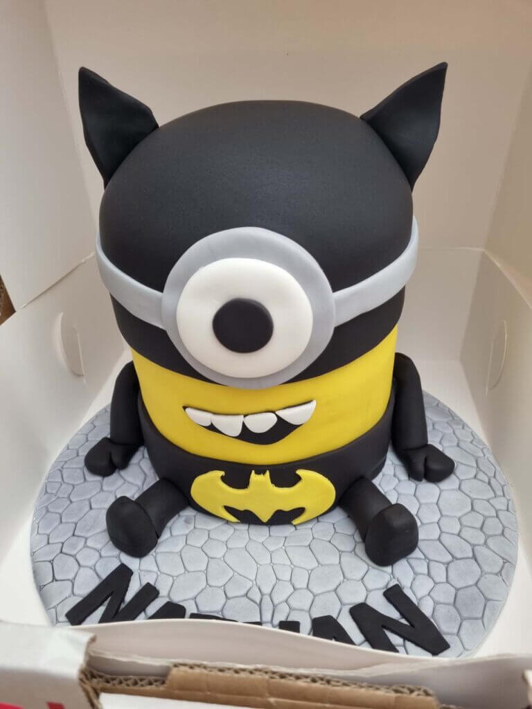 A photo of a cake shaped like a Minion dressed up as Batman, taken with the S21 Food Mode filter