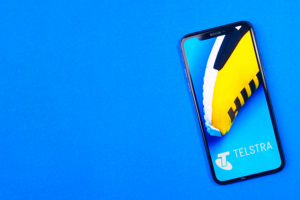 Photograph of smartphone with Telstra logo on blue background