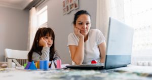 A mother and her daughter look frustrated as they stare at a laptop