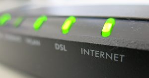 A close up shot of the front of a modem showing several green lights