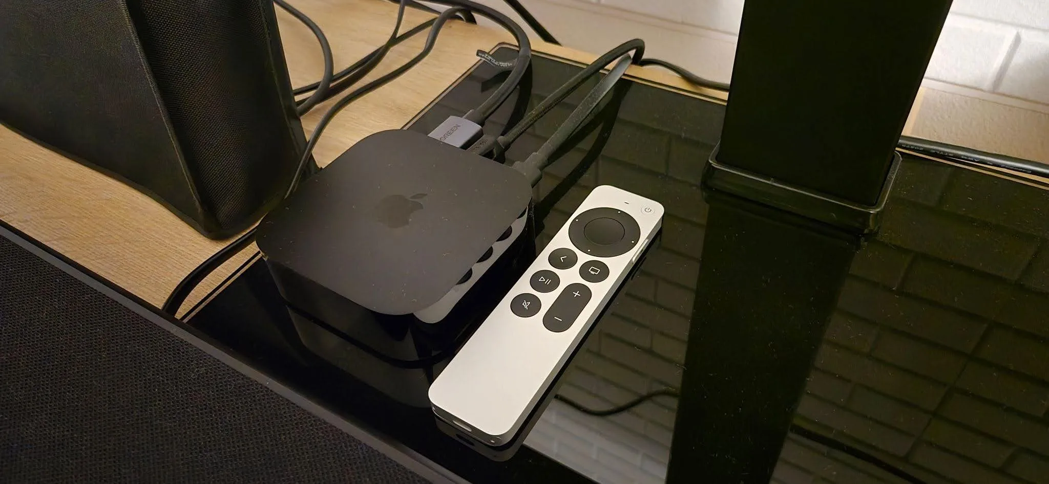 Siri remote and Apple TV 4K device hooked up in a home theater.