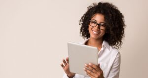 Woman smiling while using her tablet - Optus Tablet Plans