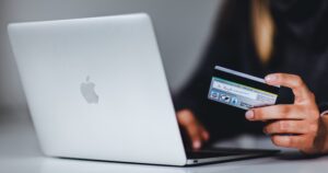 woman running a credit check on a silver MacBook