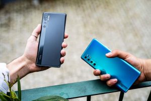 Two hands holding different colours of the TCL 20 Pro 5G