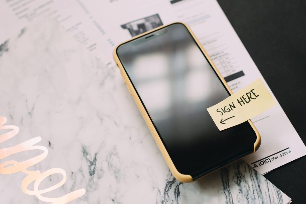 An iPhone sitting on top of a phone contract