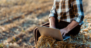 Photograph of a man using satellite internet on a laptop in rural Australia