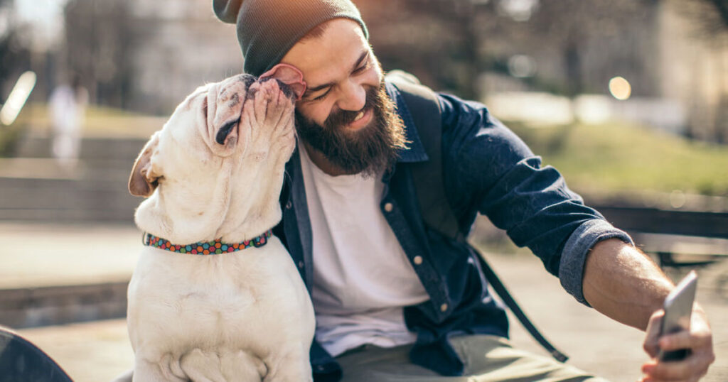 man takes a selfie on his cellphone with his dog