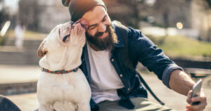 man takes a selfie on his cellphone with his dog