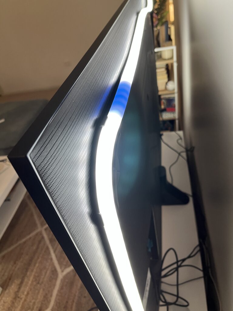 Philips Hue Play Gradient Lightstrip lit up in a rainbow on the back of a TV.