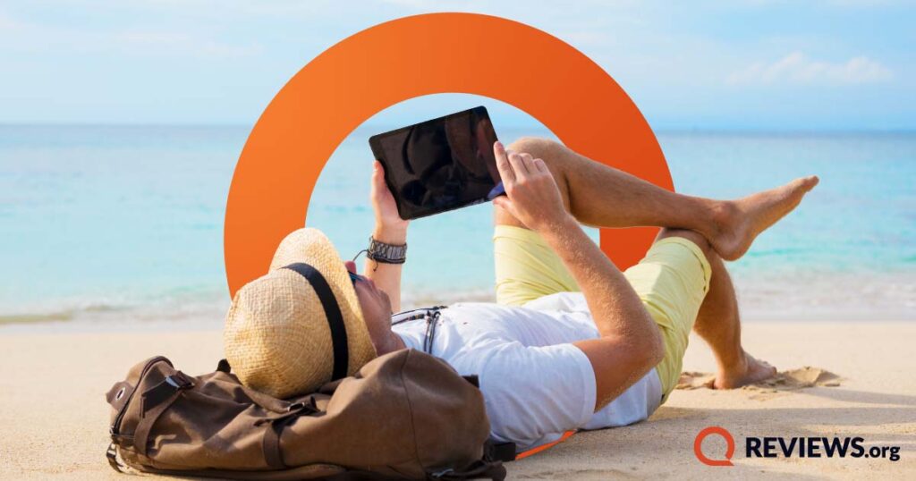 person laying on back on beach using ipad with illustration in background