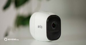 arlo security camera on a shelf near a plant