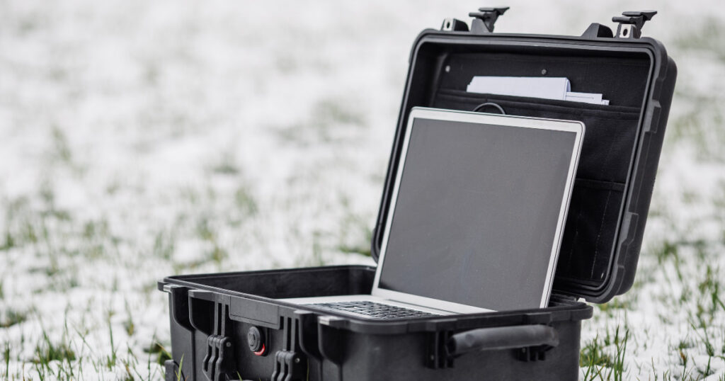 .Opened plastic protector case with laptop lying on the grass an