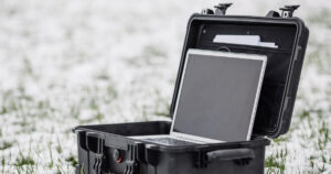 .Opened plastic protector case with laptop lying on the grass an