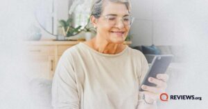an older woman smiling at her phone