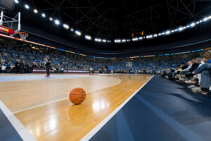 Basketball sitting on open court of a full stadium