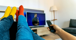 a couple wearing socks watching a man play the saxophone on tv