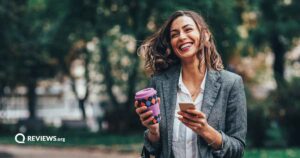 Happy woman using cell phone on a walk outisde