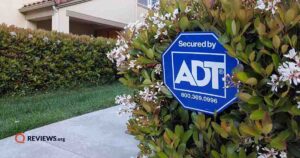 ADT sign in a bush near a driveway