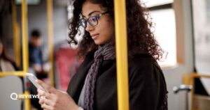 A woman looks at her phone on the subway