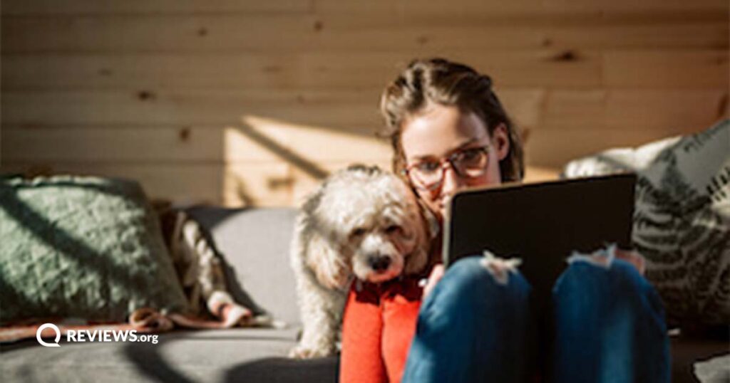 woman sitting on floor with poodle using laptop
