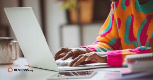woman wearing colorful sweater using laptop