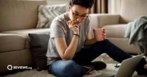 Young woman working at home while drinking a warm drink