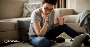 Young woman working at home while drinking a warm drink