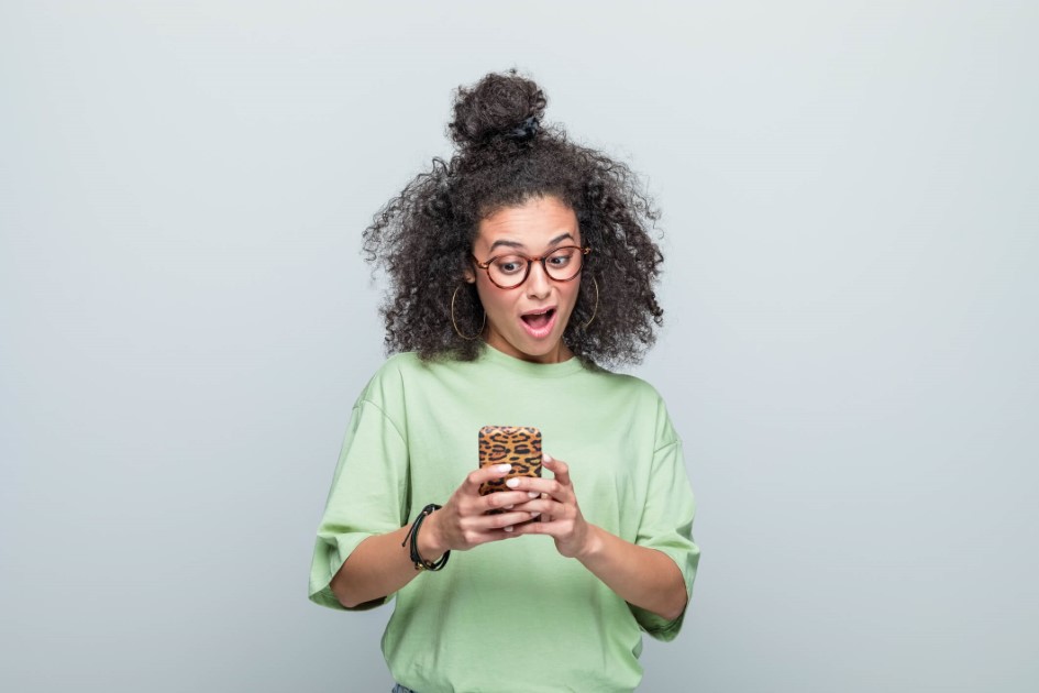 woman holding phone and looking surprised