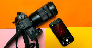 iPhone 15 Pro and Fujifilm mirrorless camera on a tri-coloured background