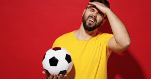 Photograph of a man holding a soccer ball