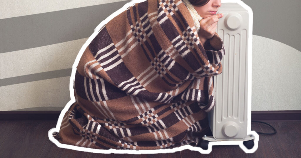 woman in plaid blanket hugging an oil heater