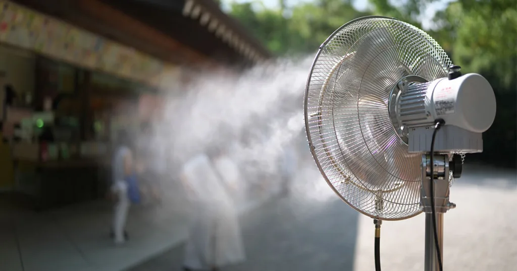 stainless steel fan blowing a fine water mist outside