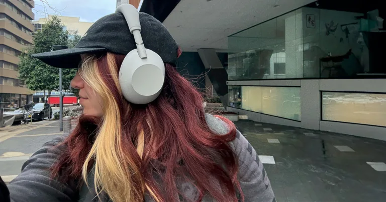 woman with red and blonde hair wearing the Sony WXM6 headphones. Portrait view