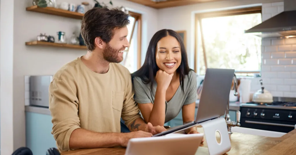 Couple comparing cheap internet options on a laptop