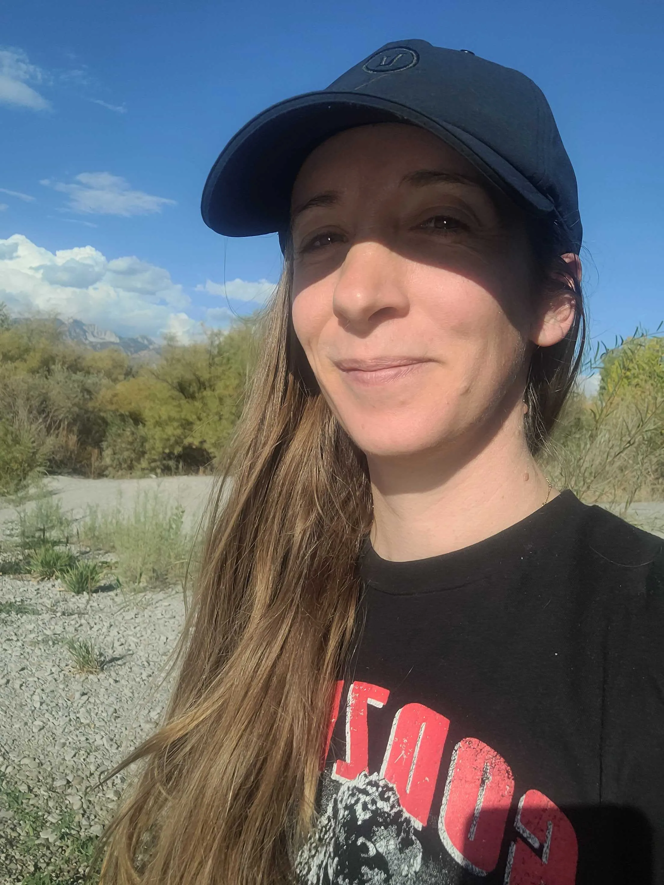 Image of Monica in a baseball cap by the river testing Mint Mobile data speeds